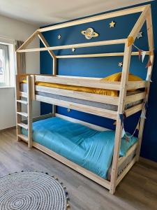 Ce lit superposé se trouve dans un dortoir doté d'un mur bleu. dans l'établissement Villa Vief Lommel, à Lommel