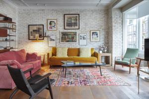 - un salon avec un canapé jaune et deux chaises dans l'établissement Dear Oldie Apartment by FeelFree Rentals, à Saint-Sébastien