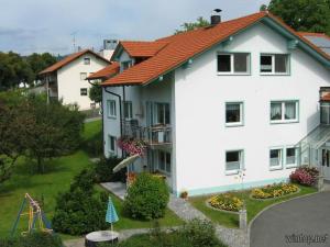 une grande maison blanche avec une aire de jeux dans la cour dans l'établissement Ferienwohnung Gottal Christine, à Neuschönau