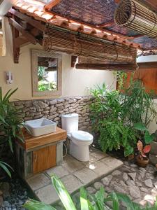 an outdoor bathroom with a toilet and a sink at Katang - Katang Guest House in Denpasar