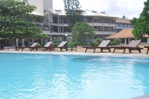 a swimming pool with benches in front of a building at Laya Beach in Wadduwa