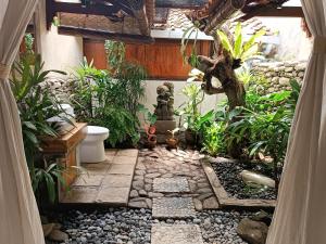 an outdoor garden with plants and a stone walkway at Katang - Katang Guest House in Denpasar