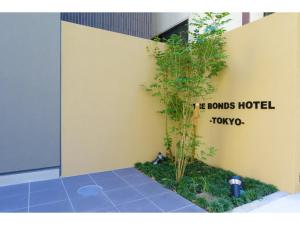 Un edificio con un cartello che dice che obbliga l'hotel tokyo di THE BONDS HOTEL TOKYO - Vacation STAY 48446v a Tokyo