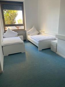dwa łóżka w pokoju z oknem w obiekcie Schicke Monteurunterkunft in Mendig mit drei Wohneinheiten w mieście Mendig