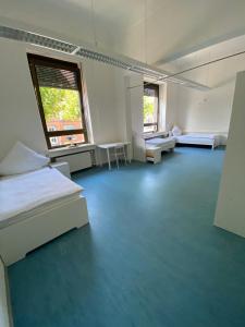 a large room with several beds and a window at Schicke Monteurunterkunft in Mendig mit drei Wohneinheiten in Mendig