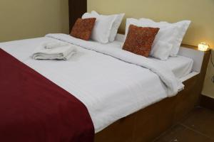 En eller flere senge i et værelse på Urmila Homestay