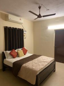 1 dormitorio con 1 cama y ventilador de techo en Ocean Shores, en Chennai