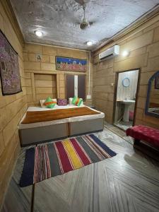 1 dormitorio con 1 cama grande y 1 alfombra en Hotel Shahiraj Jaisalmer, en Jaisalmer