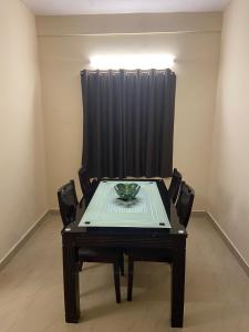 清奈的住宿－Ocean Shores，一张桌子和椅子,位于一间黑色窗帘的房间