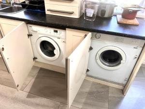 una cocina con lavadora y secadora bajo una barra en Ensuite Room Platinum 1 Harborne - Quinton Road, en Birmingham