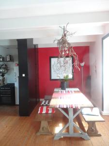 ein Esszimmer mit einem Tisch und einer roten Wand in der Unterkunft Maison de famille sur l'île de Groix in Groix