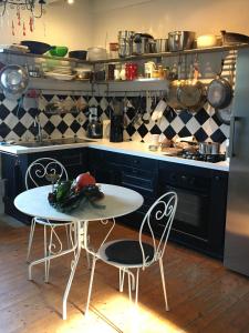 eine Küche mit einem weißen Tisch und 2 Stühlen in der Unterkunft Maison de famille sur l'île de Groix in Groix