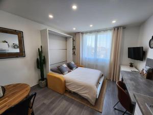 um quarto com uma cama, uma mesa e uma secretária em Le Repaire - Studio avec parking à 550m de la mer em Houlgate