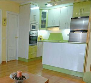 Una cocina con gabinetes blancos y una mesa en ella. en Espectaculares vistas mar Mediterraneo, en La Manga del Mar Menor