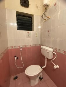 łazienka z białą toaletą i oknem w obiekcie Ocean Shores w mieście Ćennaj