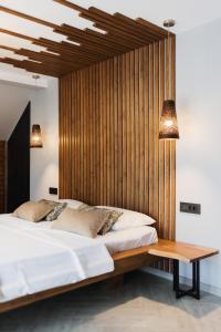 a bedroom with a large bed and a wooden wall at Casa Cerbului in Baia-Sprie