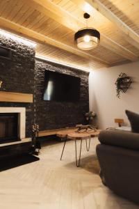 sala de estar con chimenea y TV de pantalla plana en Casa Cerbului en Baia-Sprie