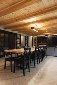 a dining room with a wooden table and chairs at Casa Cerbului in Baia-Sprie