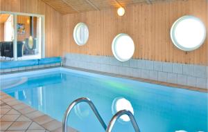 una piscina con tre specchi circolari sul muro di Lovely Home In Thisted With Indoor Swimming Pool a Klitmøller