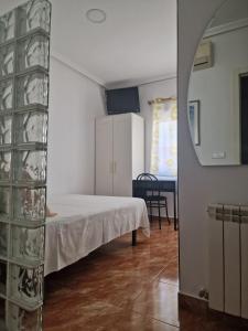 ein Schlafzimmer mit einem Bett und einem Tisch in einem Zimmer in der Unterkunft Pensión Navarra in Madrid