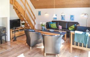 een woonkamer met een bank en een tafel bij Nice Home In Oksbl With Sauna in Mosevrå