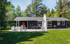 un cobertizo blanco y negro con terraza en un patio en Cozy Home In Hals With Kitchen, en Hals