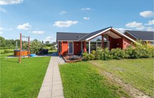 una casa rossa con un prato verde davanti di Amazing Home In Frrup With Wifi a Frørup
