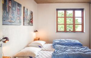 KnebelにあるNice Home In Knebel With 3 Bedrooms And Wifiのベッドルーム1室(ベッド2台、窓付)