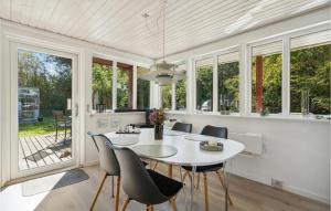 jadalnia z białym stołem i krzesłami oraz oknami w obiekcie Valndden w mieście Søndervig