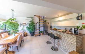 a kitchen and dining room with a table and some plants at Cozy Apartment In Kastel Novi in Kastel Novi
