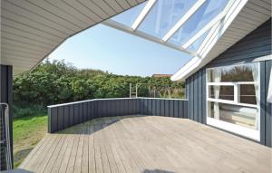 a patio with a wooden deck with a glass roof at Cozy Home In Hvide Sande With Kitchen in Havrvig