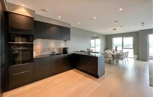 a kitchen with black cabinets and a dining room at 3 Bedroom Beautiful Apartment In Haugesund in Haugesund