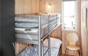 a bunk bed room with two bunk beds and a chair at Awesome Home In Thisted With 4 Bedrooms, Sauna And Wifi in Nørre Vorupør