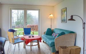 - un salon avec un canapé, des chaises et une table dans l'établissement Cozy Home In Kirke Hyllinge With Kitchen, à Sæby