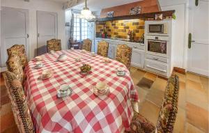 una cocina con una mesa y sillas de color rojo y blanco a cuadros. en Awesome Home In Charlieu With Wifi And 7 Bedrooms, en Charlieu