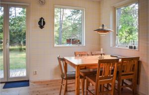 een eetkamer met een houten tafel en stoelen bij Gorgeous Home In Frjestaden With Wifi in Färjestaden