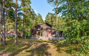 een blokhut in het bos met bomen bij Gorgeous Home In Frjestaden With Wifi in Färjestaden