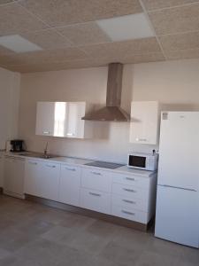 a kitchen with white cabinets and a white refrigerator at Albergue de Maella in Maella