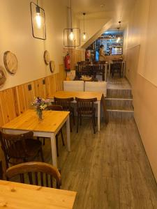 un restaurante con mesas y sillas de madera y una escalera en Laurear Guest House, en Oporto