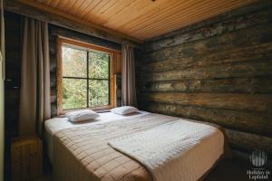 a bed in a room with a window at Holiday in Lapland - Levin Sudenpesä in Sirkka