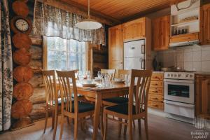 希爾卡的住宿－Holiday in Lapland - Levin Sudenpesä，厨房配有木桌、椅子和炉灶