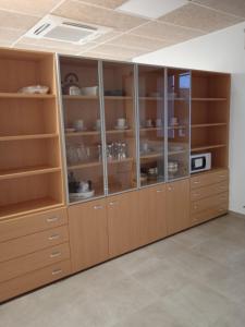 un gran armario de madera con puertas de cristal en una habitación en Albergue de Maella, en Maella