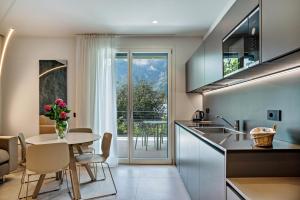 eine Küche und ein Esszimmer mit einem Tisch und Stühlen in der Unterkunft Appartamento Midum Garden Sud in Trient