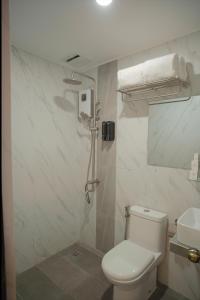 a bathroom with a shower and a toilet and a sink at Ragazzi Resort Hotel in Naga
