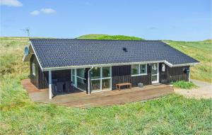 a small house with a deck in a field at Cozy Home In Harbore With House A Panoramic View in Harboør