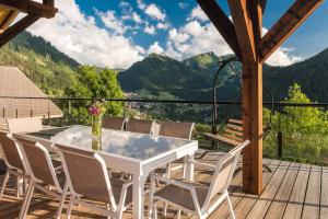 a white table and chairs on a deck with mountains at Chalet Familial Le Whymper 5 étoiles SPA Sauna Chatel in Châtel