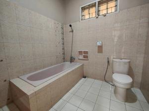 La salle de bains est pourvue d'une baignoire et de toilettes. dans l'établissement De Hanami Homestay Setrayasa, à Cirebon