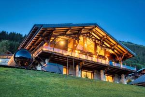 a large wooden house on top of a hill at Chalet Familial Le Whymper 5 étoiles SPA Sauna Chatel in Châtel