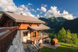 a house with a balcony with a view of the mountains at Chalet Familial Le Whymper 5 étoiles SPA Sauna Chatel in Châtel