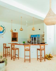 a kitchen with a wooden counter and stools at Mnana Beach Bungalows in Michamvi